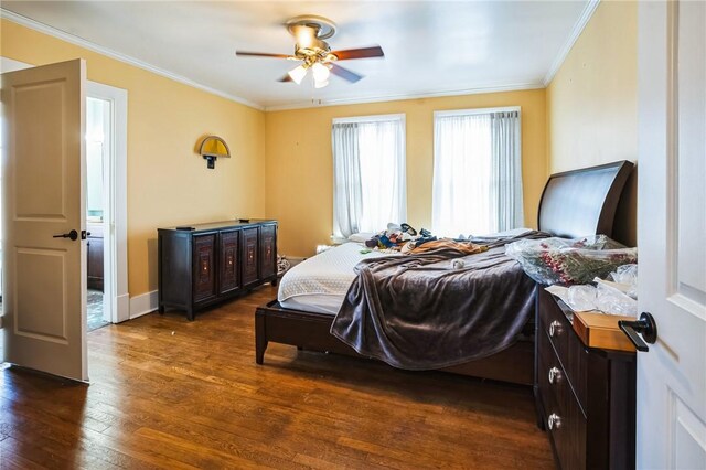 bedroom featuring baseboards, dark wood-type flooring, a ceiling fan, and ornamental molding