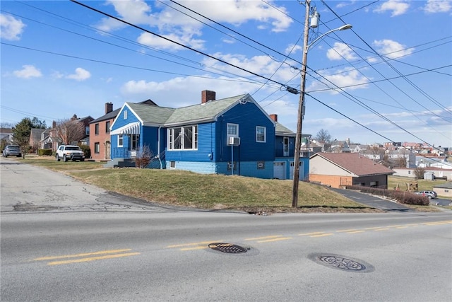 view of front of home featuring a residential view, a chimney, and a front yard