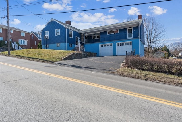 view of front facade featuring driveway, stairs, and a garage