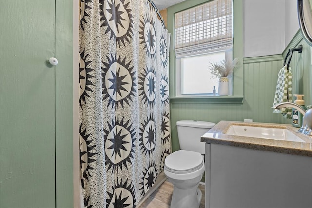 bathroom with a shower with shower curtain, toilet, vanity, and wood finished floors