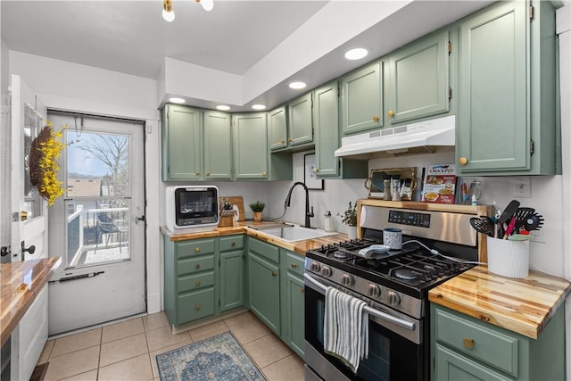 kitchen featuring green cabinets, stainless steel gas range, under cabinet range hood, and a sink