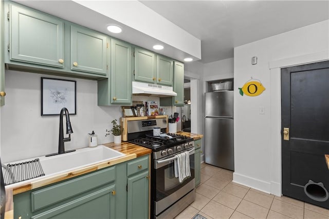 kitchen featuring under cabinet range hood, stainless steel appliances, and green cabinetry