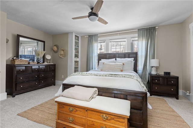 bedroom with multiple windows, light colored carpet, and baseboards