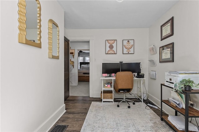 office area featuring dark wood finished floors, visible vents, and baseboards