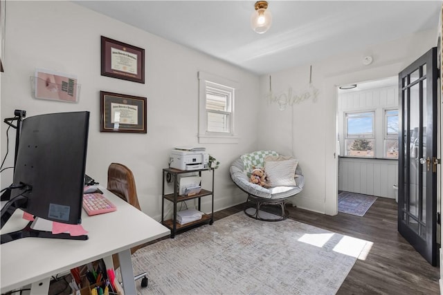 office area with wood finished floors, radiator, a healthy amount of sunlight, and baseboards