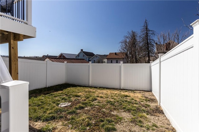 view of yard featuring a balcony and a fenced backyard