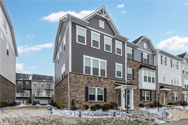 townhome / multi-family property featuring stone siding, board and batten siding, and a residential view