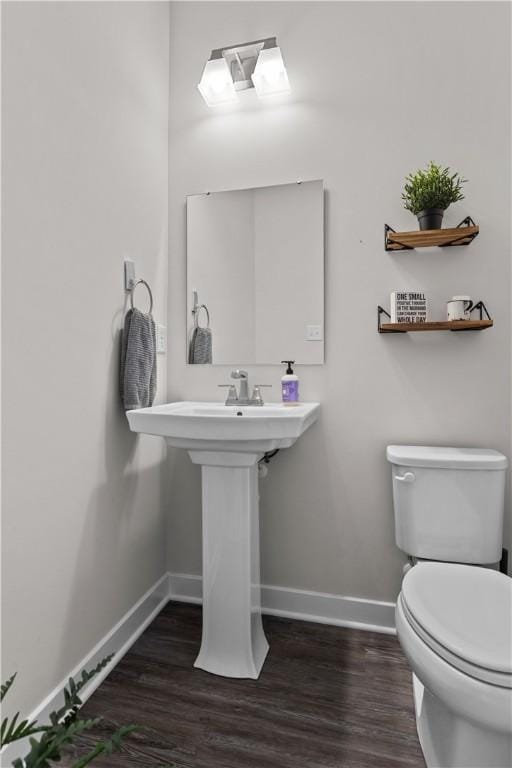 bathroom with toilet, wood finished floors, and baseboards