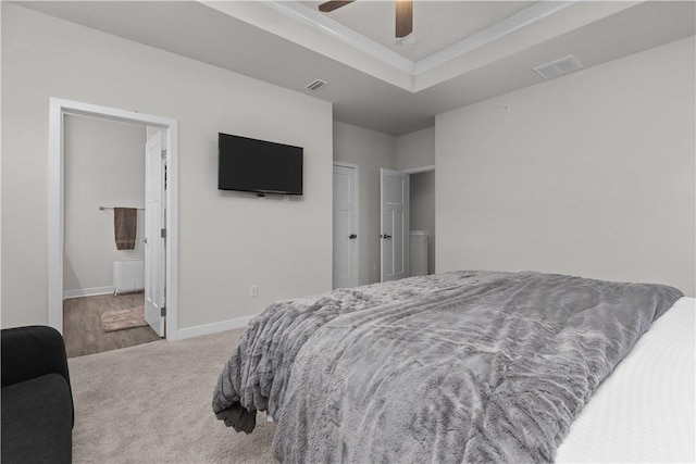 bedroom with a raised ceiling, carpet, visible vents, and baseboards