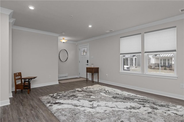 empty room with dark wood finished floors, crown molding, and baseboards