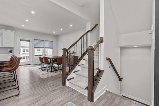 staircase with recessed lighting, baseboards, and wood finished floors