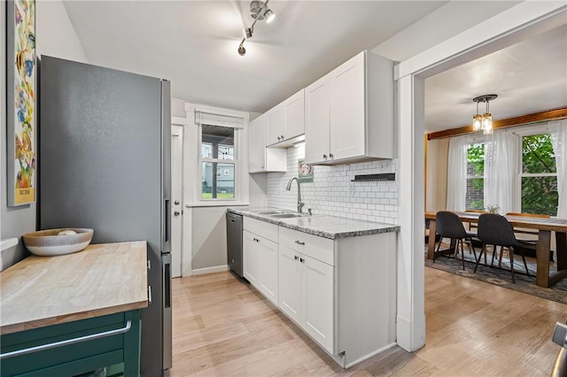 kitchen featuring a sink, stainless steel appliances, light wood-style floors, and white cabinetry