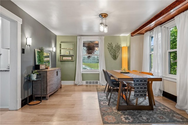 dining room featuring visible vents, baseboards, and wood finished floors