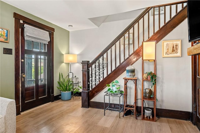 entryway featuring stairway, baseboards, and wood finished floors