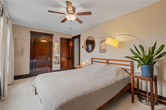 bedroom featuring a ceiling fan, light colored carpet, and baseboards