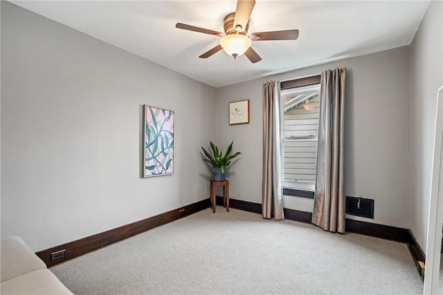 interior space featuring visible vents, light colored carpet, a ceiling fan, and baseboards