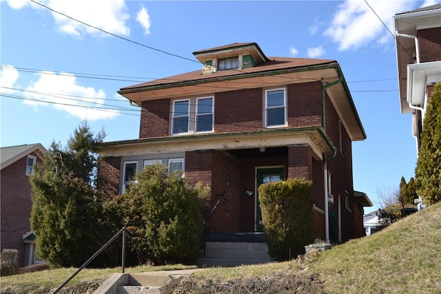 american foursquare style home with brick siding