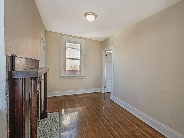 unfurnished living room with dark wood finished floors and baseboards