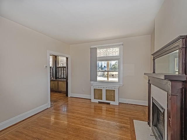 unfurnished living room with baseboards, plenty of natural light, and wood finished floors