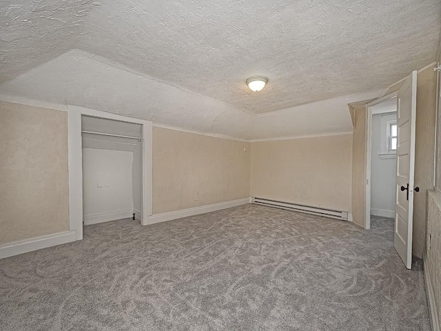 interior space featuring a baseboard radiator, lofted ceiling, a textured ceiling, and baseboards