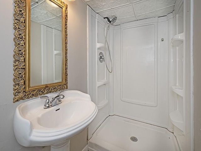 bathroom with a stall shower, an ornate ceiling, and a sink