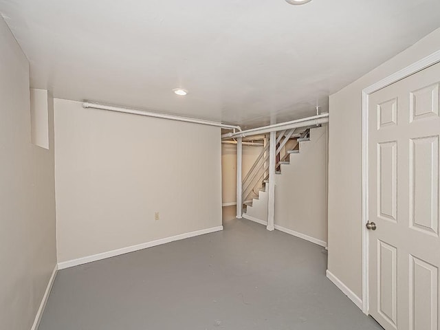 finished below grade area featuring stairs and baseboards