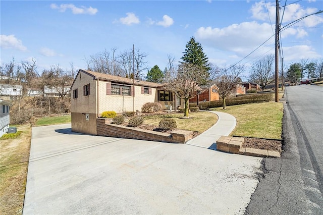 ranch-style house with a front yard and brick siding