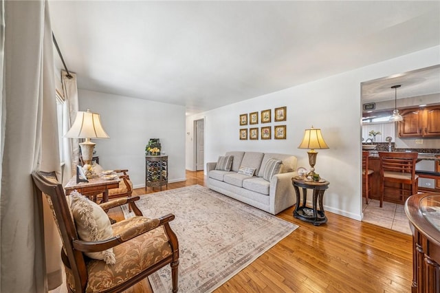 living area featuring light wood finished floors and baseboards