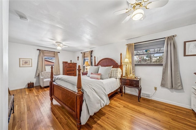 bedroom with a ceiling fan, visible vents, light wood-type flooring, and baseboards