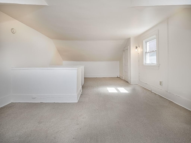 bonus room featuring lofted ceiling and light colored carpet