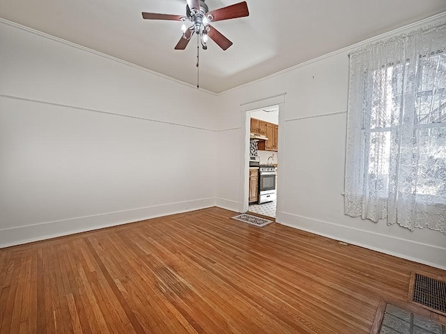 unfurnished room with visible vents, light wood-style flooring, baseboards, and ceiling fan