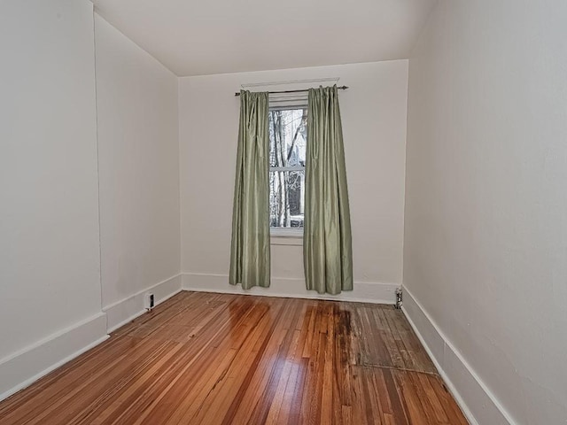 spare room with hardwood / wood-style flooring and baseboards