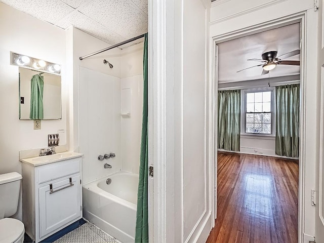 bathroom with ceiling fan, toilet, hardwood / wood-style flooring, shower / bath combination with curtain, and vanity