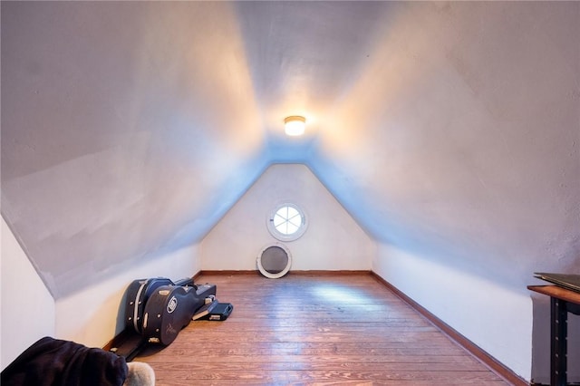 bonus room featuring hardwood / wood-style floors, vaulted ceiling, and baseboards