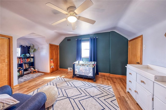 additional living space featuring visible vents, baseboards, light wood-style flooring, and vaulted ceiling