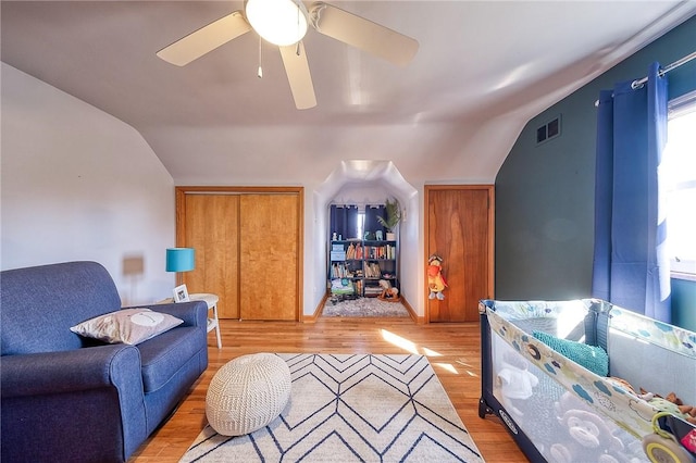 living room with vaulted ceiling, light wood-style floors, and visible vents