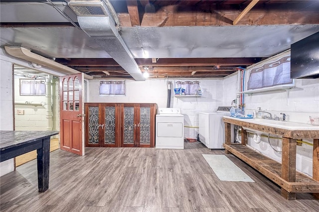 below grade area with washer and dryer, wood finished floors, and visible vents