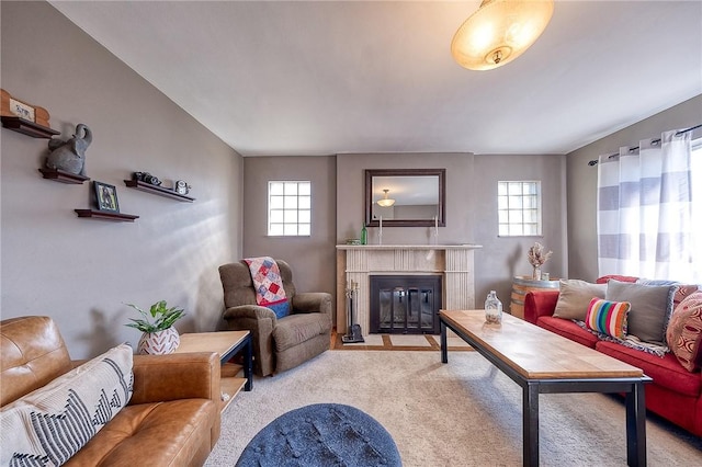 living room featuring a premium fireplace, plenty of natural light, and light colored carpet