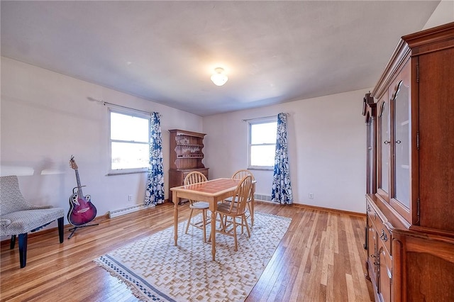 dining area featuring light wood-style flooring, baseboards, and baseboard heating