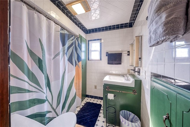 full bath with a shower with shower curtain, toilet, tile walls, and vanity