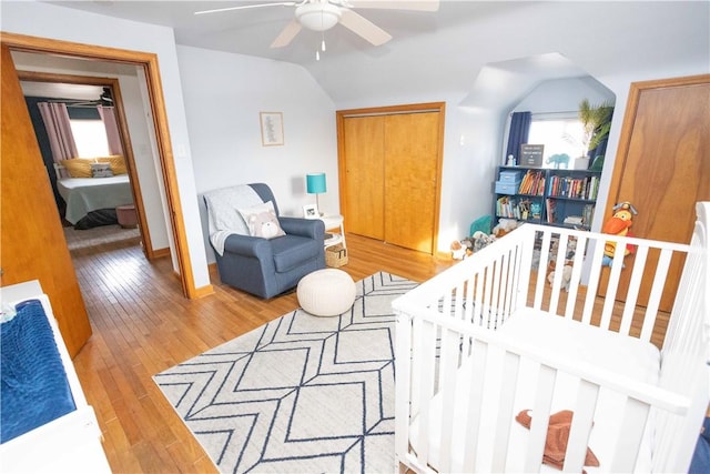 bedroom with ceiling fan, hardwood / wood-style flooring, baseboards, and vaulted ceiling