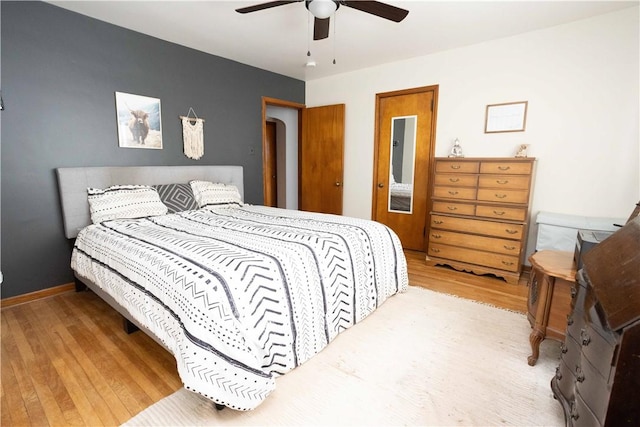 bedroom with ceiling fan, baseboards, and wood finished floors