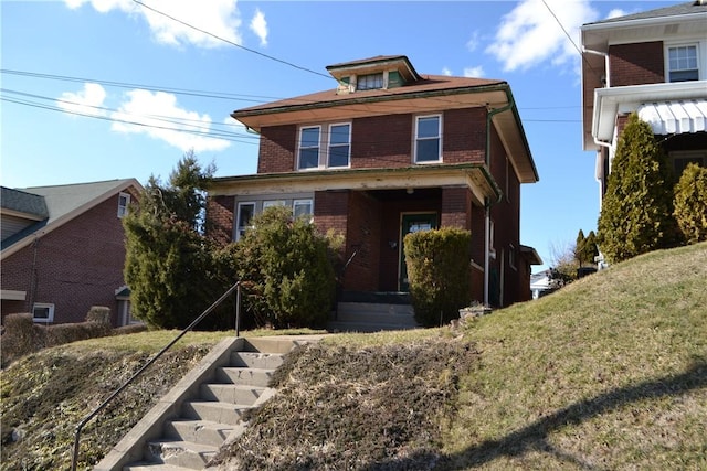 american foursquare style home featuring stairway and brick siding