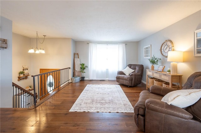 living room featuring baseboards, a notable chandelier, and hardwood / wood-style floors