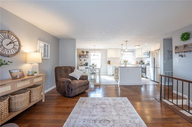 living area featuring visible vents, baseboards, and hardwood / wood-style flooring