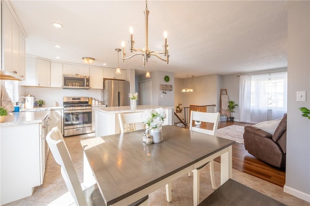 dining area with light tile patterned flooring, recessed lighting, and an inviting chandelier