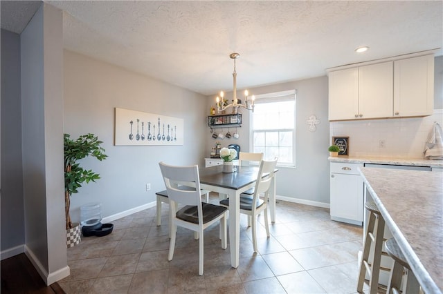 dining area with light tile patterned floors, a notable chandelier, and baseboards