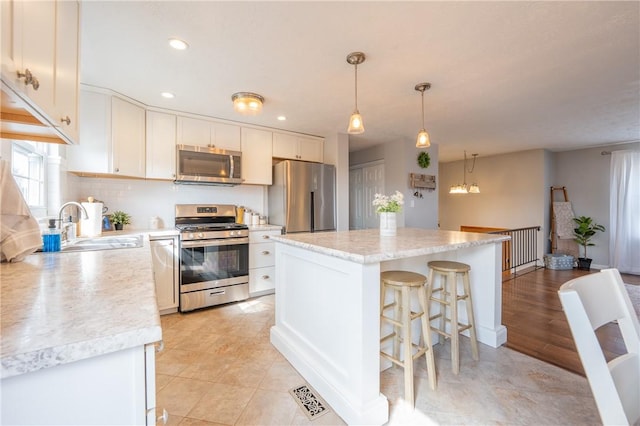 kitchen with visible vents, stainless steel appliances, light countertops, and a sink