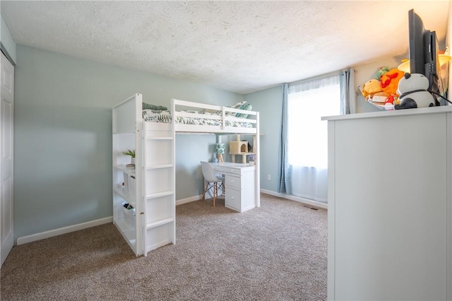 unfurnished bedroom with carpet flooring, baseboards, and a textured ceiling