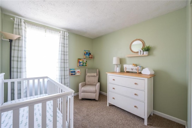 bedroom featuring baseboards, light colored carpet, a textured ceiling, and a nursery area